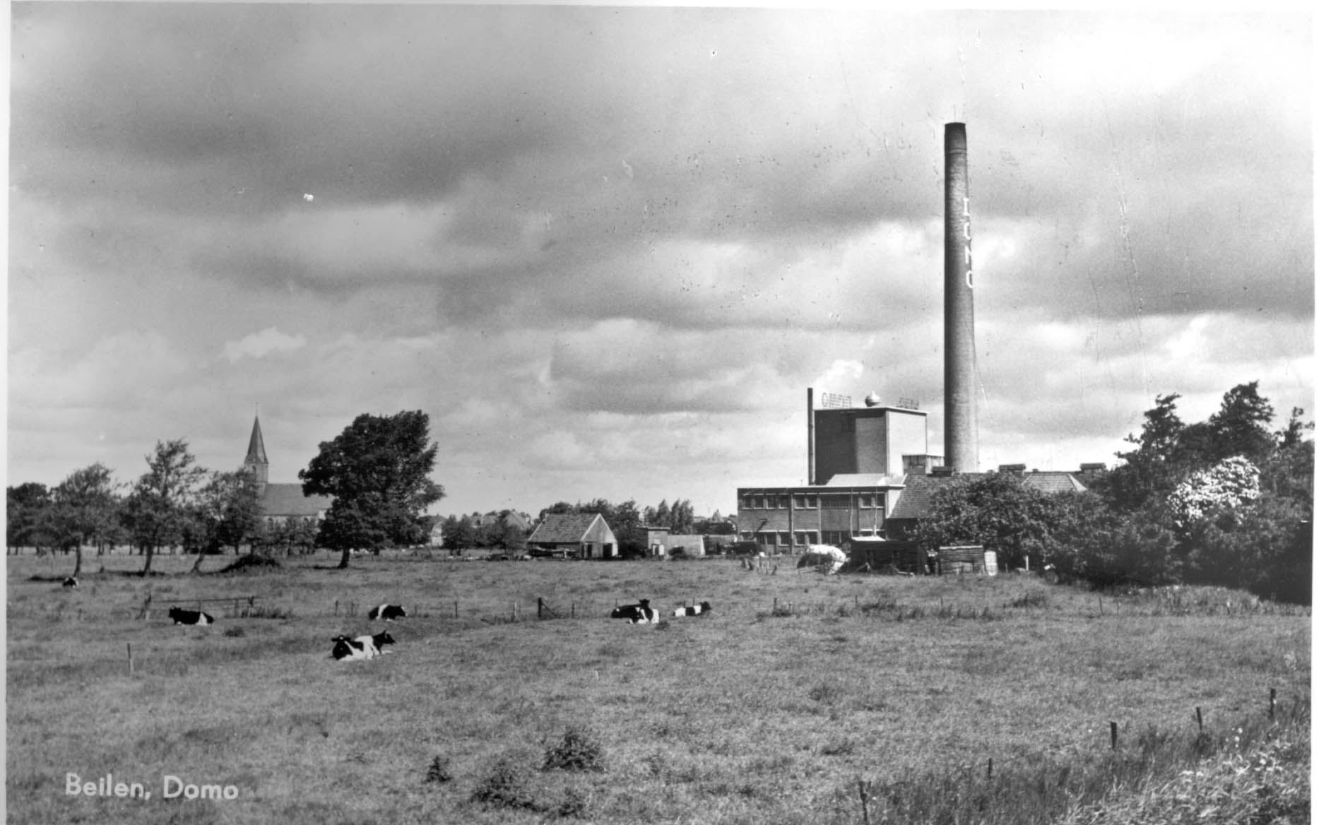 Deze foto van de DOMO is vanuit de weilanden ten zuidwesten van de fabriek genomen, links de Stephanuskerk